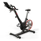 Black and red indoor stationary exercise bike with padded seat, handlebars, and digital display on white background