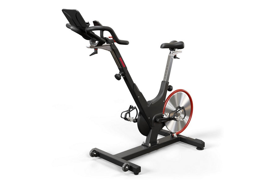 Black and red indoor stationary exercise bike with padded seat, handlebars, and digital display on white background