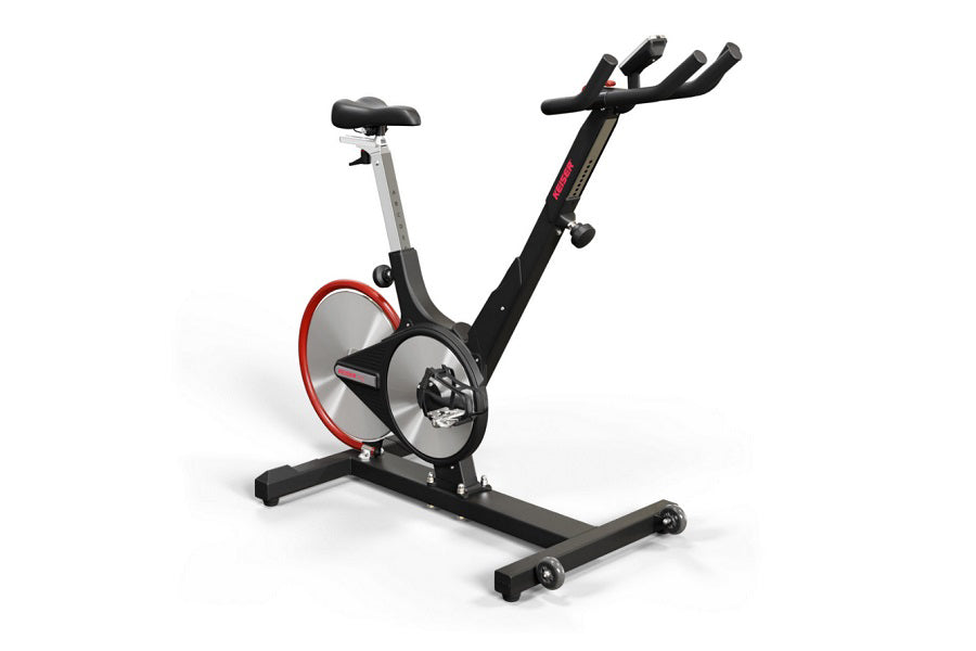 Black and red indoor exercise bike with gray frame, padded seat, dual handlebars, and weighted flywheel, shown on white backg