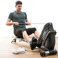 Man using black Kettler Coach E rowing machine, wearing gray t-shirt and black shorts on wooden floor