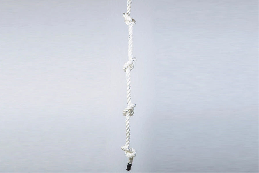 White twisted climbing rope with knotted handholds spaced evenly, black grip base, on light background