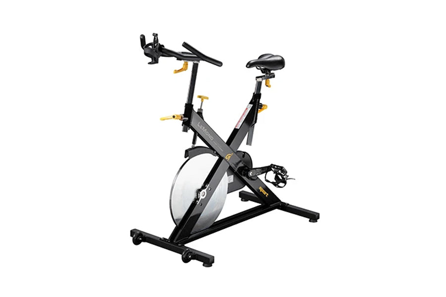 Black and gold stationary exercise bike with white wheel, padded seat, drop handlebars, and pedal straps on white background