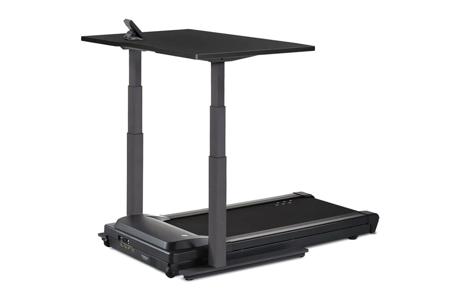 Black treadmill desk with adjustable height columns, black desktop surface, and control panel, on white background