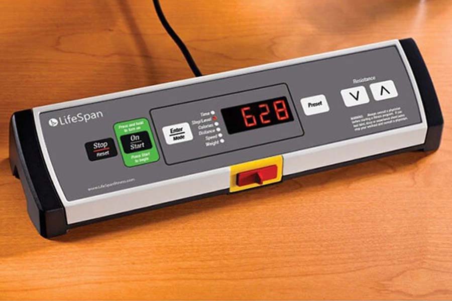 LifeSpan TR1200-GlowUp under desk treadmill with digital display showing 628, green start button, and control panel on wooden