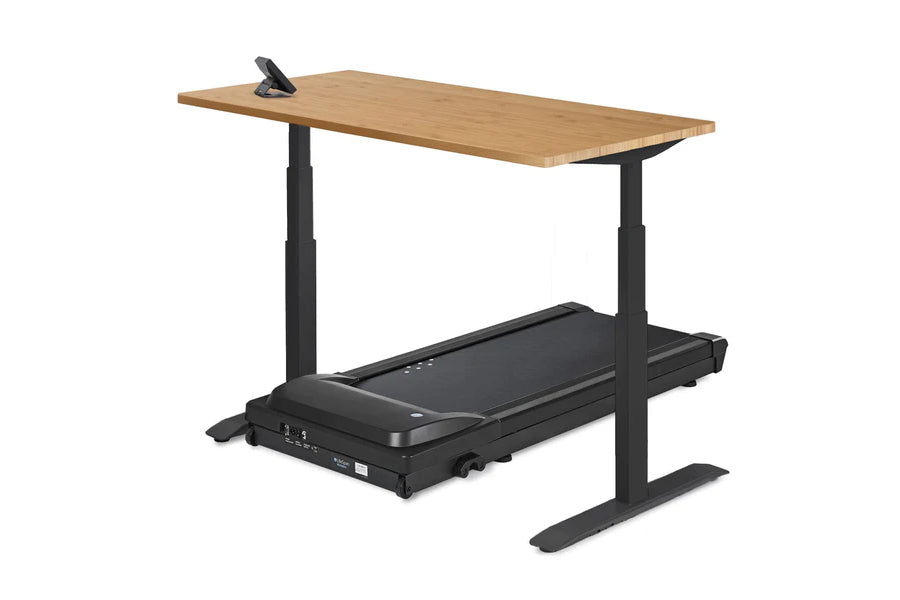 Adjustable height desk with natural wood top and black metal frame, featuring integrated treadmill base with digital controls