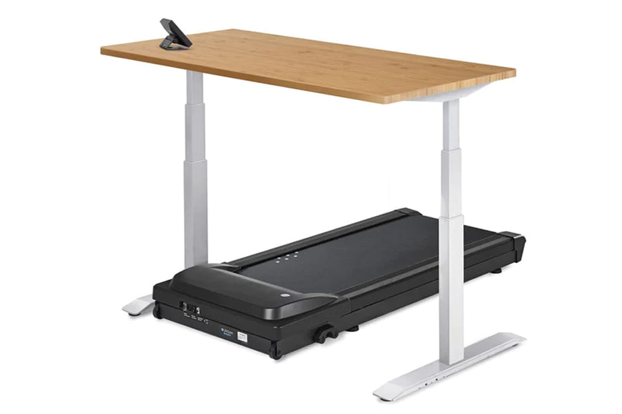 Natural wood desktop with black treadmill base and white adjustable legs, featuring phone stand on tabletop, against white ba