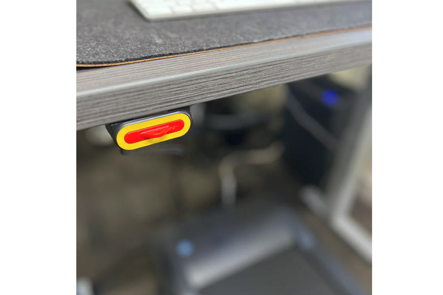Red and yellow illuminated control button on underside of LifeSpan treadmill desk