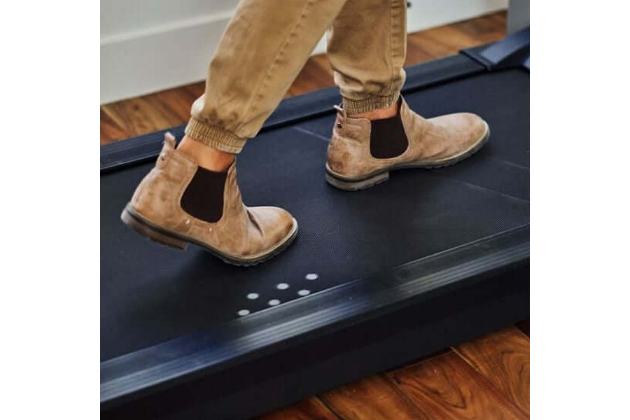 Tan suede Chelsea boots with elastic side panels worn by model on LifeSpan treadmill desk