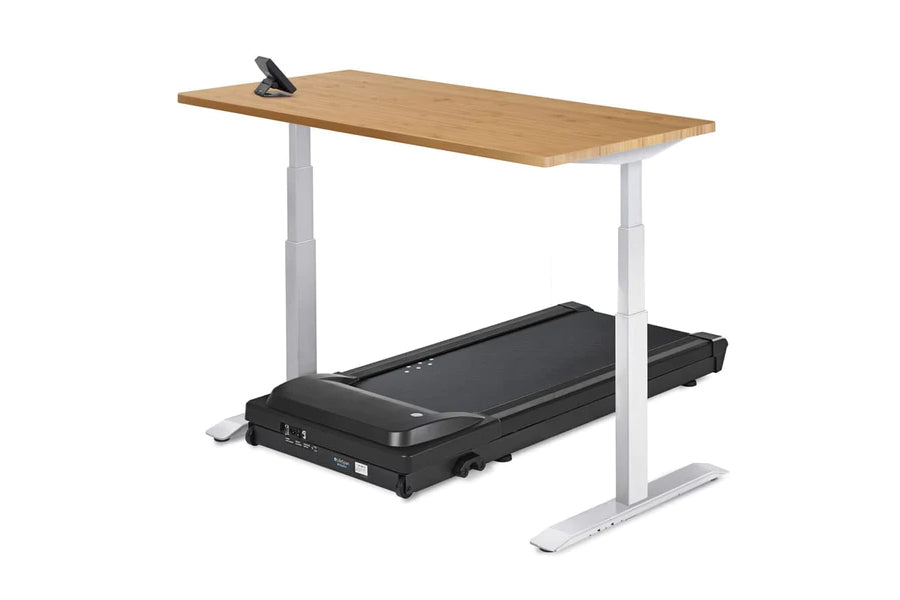 Adjustable height treadmill desk with natural wood top, white metal frame, and black motorized treadmill base with digital co