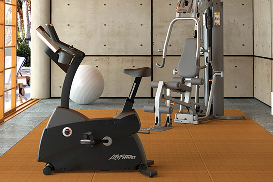 Black Life Fitness upright exercise bike with digital display in modern gym setting with concrete walls
