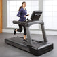 Woman running on Life Fitness Club Series Plus treadmill with digital display, wearing purple long-sleeve top and black capri