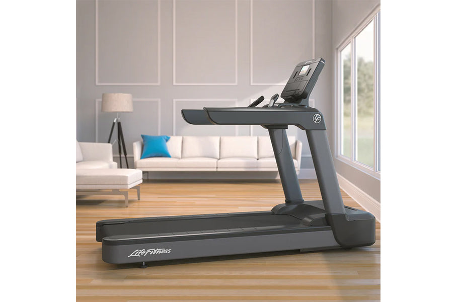 Life Fitness Club Series Plus treadmill with dark gray frame and digital display, positioned in modern living room with white