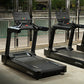Black Life Fitness club treadmill with digital display console, shown in gym setting with mirrors and windows