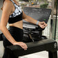 Black and white tie-dye racerback sports bra with black high-waist leggings worn by model on Life Fitness treadmill with digi