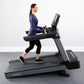 Woman running on black and gray Life Fitness treadmill with digital display, wearing navy long-sleeve shirt and black capri l