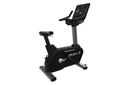 Black Life Fitness upright exercise bike with digital display console, handlebars, and foot pedals on white background