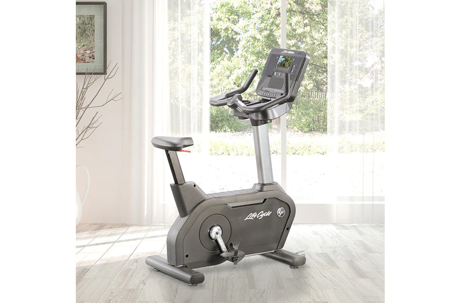 Life Fitness Club Series Plus upright stationary bike with black seat and gray frame, digital console display, in bright home