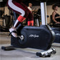 Person wearing burgundy and white colorblock leggings using black Life Cycle upright stationary bike in gym setting