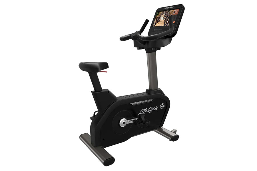 Black Life Fitness upright exercise bike with digital display console, stationary pedals, and gray base on white background