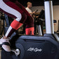 Burgundy, white, and coral colorblock leggings worn by model on stationary bike in fitness studio