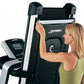 Woman in yellow tank top using Life Fitness folding treadmill with black and silver frame and digital console