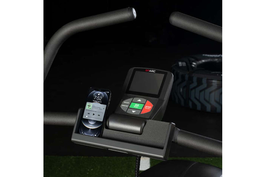 Black SPARC Arc Trainer console with digital display, control buttons in green and red, smartphone holder, mounted on curved 