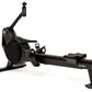 Black rowing machine with digital monitor, adjustable foot pedals, and extended sliding seat on white background
