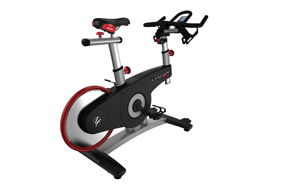 Life Fitness LifeCycle GX stationary bike with black frame, red wheel trim, silver handlebars, and red padded seat on white b