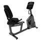 Life Fitness RS1 recumbent stationary bike with black padded seat, gray frame, digital display console, and foot pedals on wh