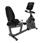 Black and gray recumbent exercise bike with padded seat, digital console display, and foot pedals on white background