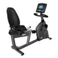 Black recumbent exercise bike with digital console display, padded seat and backrest, mounted on gray frame against white bac