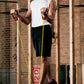 Man using yellow resistance band handles with red grip ends during workout in industrial gym setting