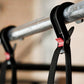 Black pull-up assistance band with red accent detail hanging on metal bar