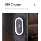 White oval USB charger with black center panel mounted on dark leather furniture