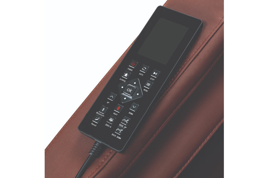 Black remote control with display screen and multiple buttons on brown leather massage chair