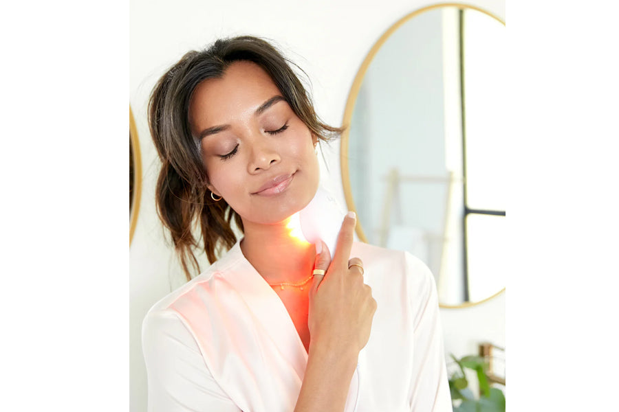 Woman using red LED light therapy device on neck, demonstrating wrinkle treatment use