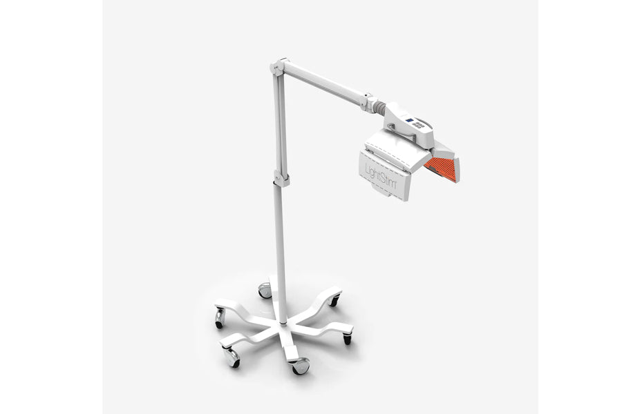 LightStim ProPanel LED light therapy lamp with white adjustable arm and rolling base, featuring orange-accented panel head on