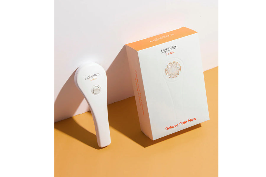 White handheld LightStim LED light therapy device next to product box on yellow background