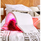 White LED light therapy lamp with pink glowing dome emitting LED light, shown on bed with model wearing treatment cap