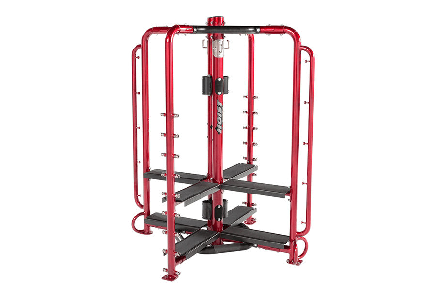 Red and black multi-station gym cage with cable machine, black foot plates, and weight pegs on white background