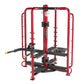 Red and black multi-station home gym with cable machines and weight stacks on white background