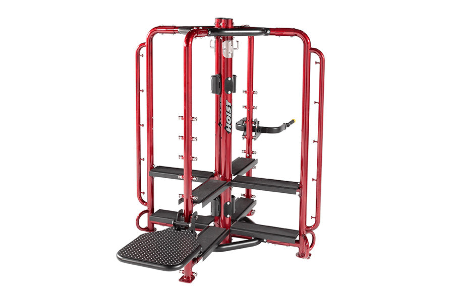 Red and black multi-station gym equipment with safety cage frame, adjustable weight arms, and textured black footplate on whi