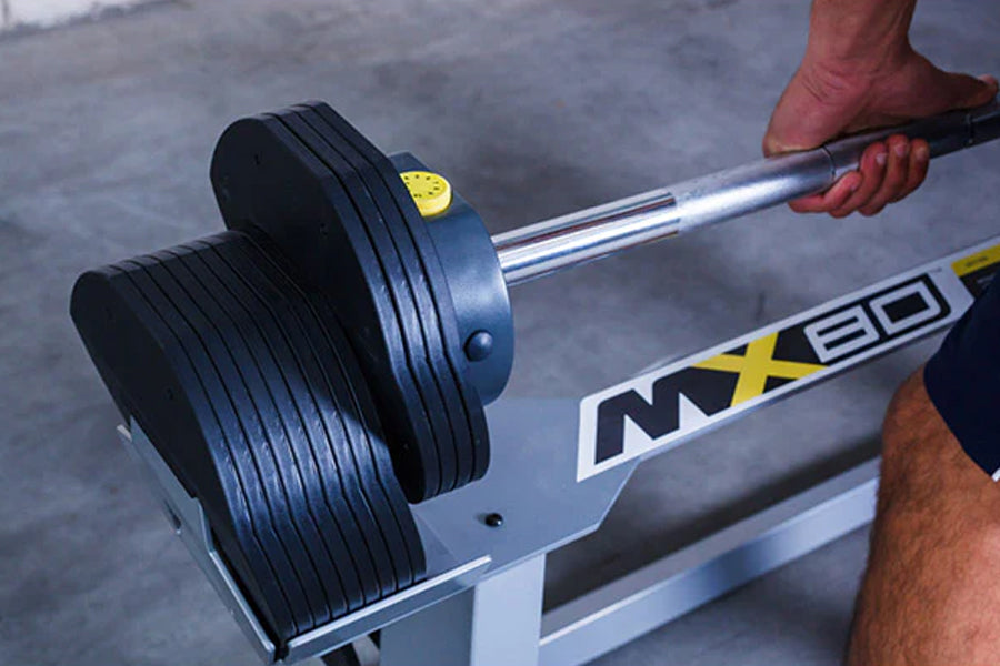 MX80 adjustable barbell with black rubber plates and chrome bar held by person's hand during workout