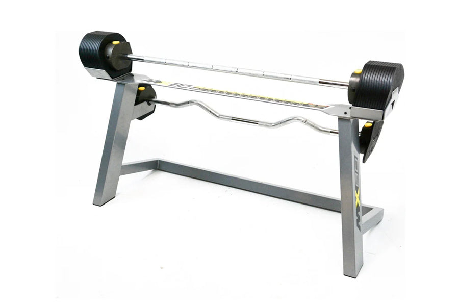Adjustable dumbbell and barbell system with gray frame, black rubber-coated weight plates, and curved curl bar, on white back