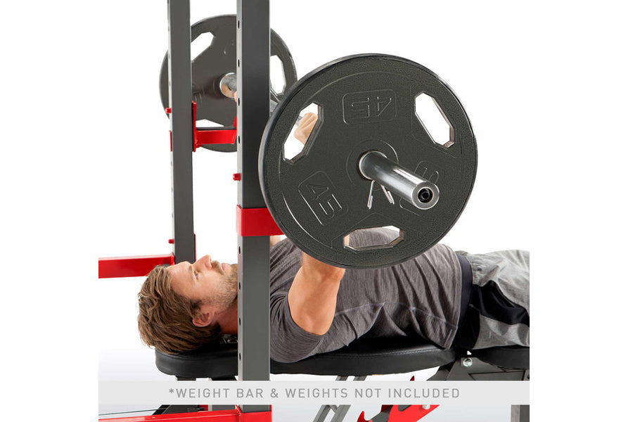Man performing chest press exercise on Marcy Pro Smith Machine with black weight plates and red frame details
