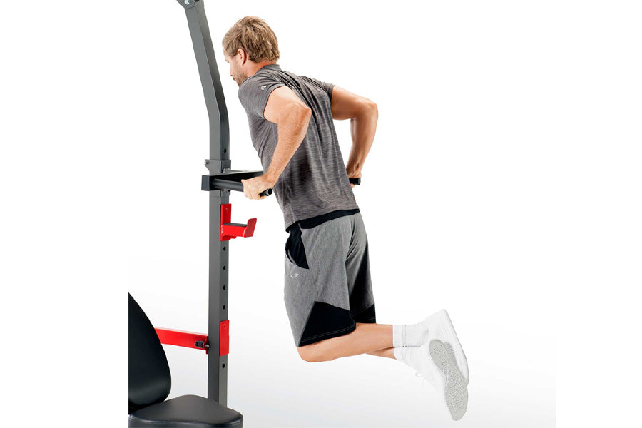 Man using gray and red Smith machine with black seat and foot platform on white background