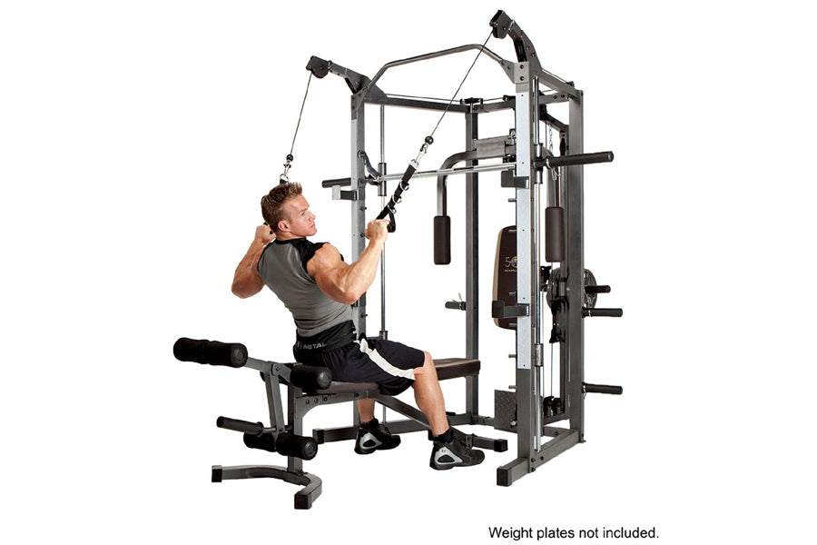 Man using gray and black Smith machine home gym with cable attachments and weight plate pegs on white background