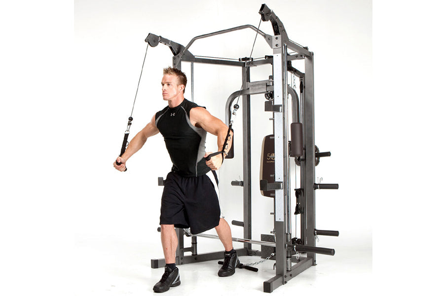 Man using black and gray Marcy Smith machine home gym with cable attachment on white background