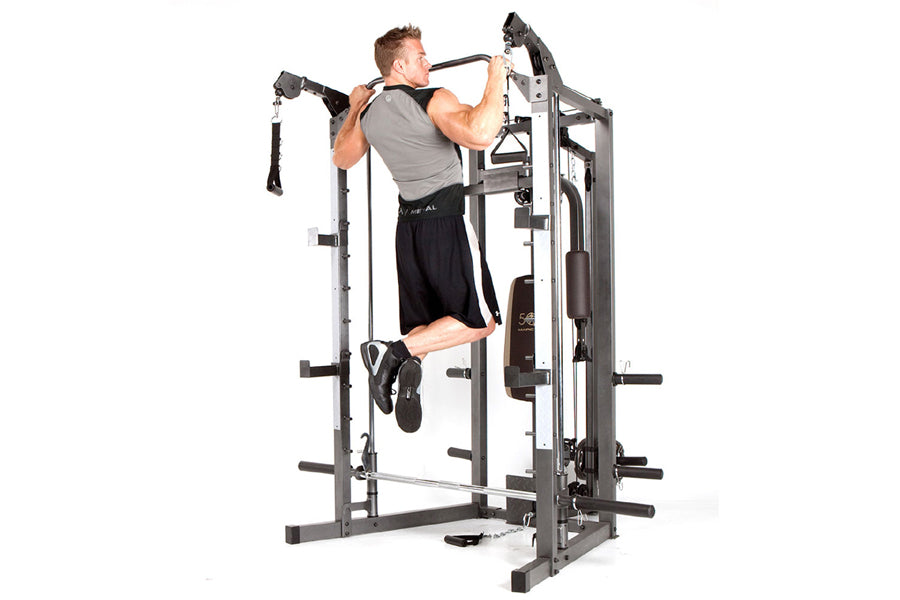 Man using gray and black Smith machine home gym for upper body workout on white background