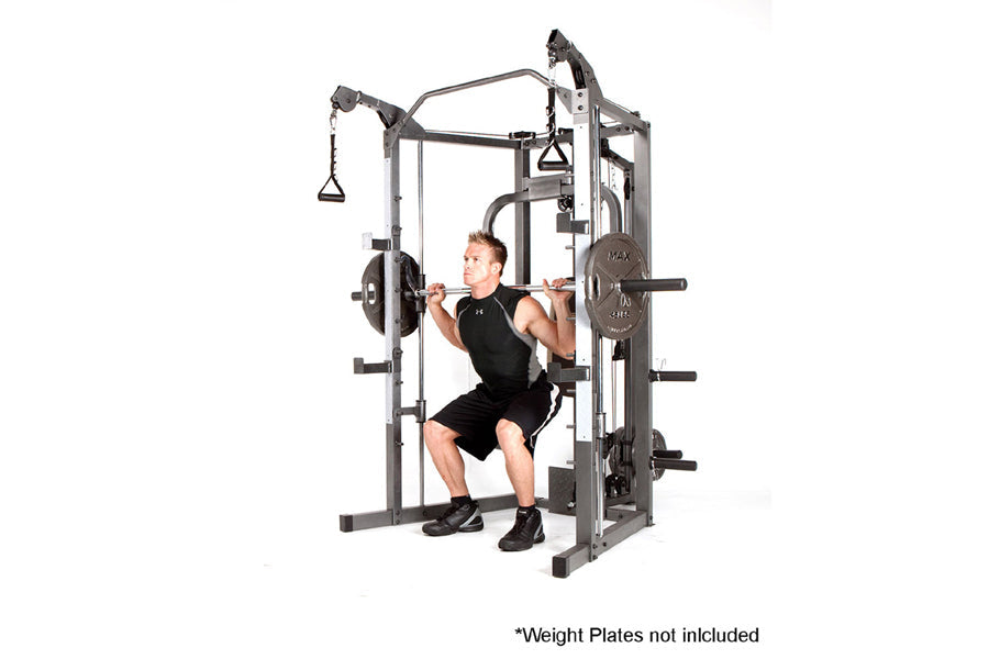 Marcy Smith Machine home gym with gray steel frame, weight plate posts, and cable attachments, demonstrating squat position w